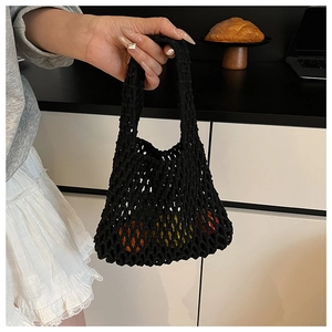 Detail of hand-held black hollow out knit tote bag with large mesh weave and single handle