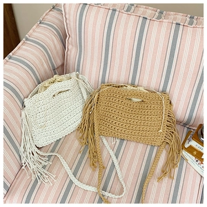 Detail of bohemian cotton crochet tote bags in beige and brown with tassels