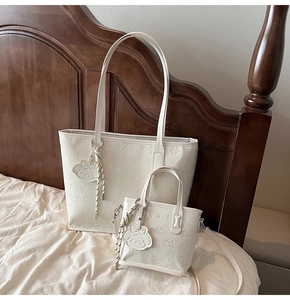Détails d'un ensemble de sacs blancs gaufrés avec pendentifs de personnages mignons