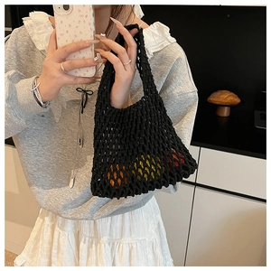 Detail of black hollow out knit tote bag showing elastic mesh texture and large capacity