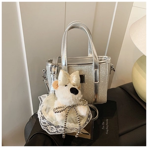 Silver sequin bucket bag featuring a cute plush dog charm and a detachable strap