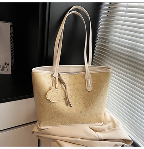 Gros plan sur le sac fourre-tout crème avec motifs d'ours en relief et charm mignon