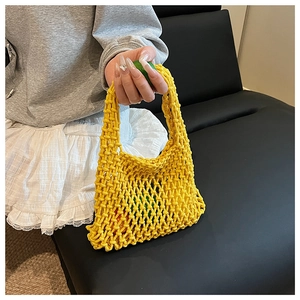 Detail of yellow knit hollow handbag showing intricate rope mesh texture with citrus fruit