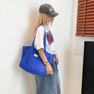 Détail du grand sac cabas matelassé bleu vif avec motif à losanges et étiquette