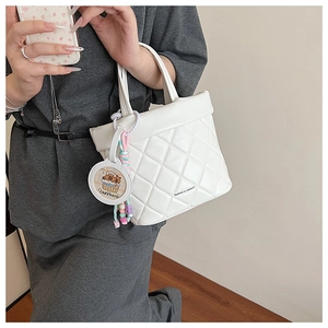 Detail of white quilted handbag with Capybara charm and colorful beaded decoration