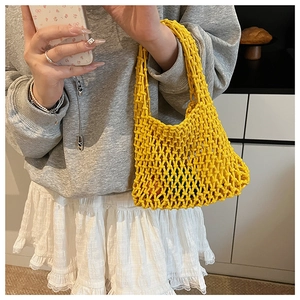 Detailed knit texture of a yellow handmade hollow crochet handbag for summer outings