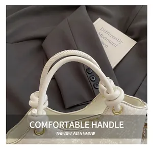 Détail du sac seau blanc avec poignée nouée unique et anneaux métalliques dorés chic