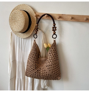 Close-up of hollow crochet shoulder bag with dark wood beads and a bohemian vibe
