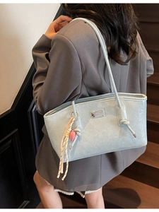 Fashionable light blue tote bag with wrinkled leather texture and knot shoulder strap