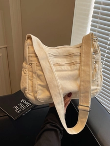Minimalist beige canvas crossbody tote bag with multi-zipper pockets and wide strap