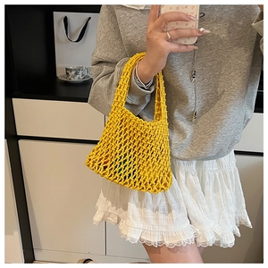 Detailed close-up of the hollow-out knit handbag in vibrant yellow woven texture