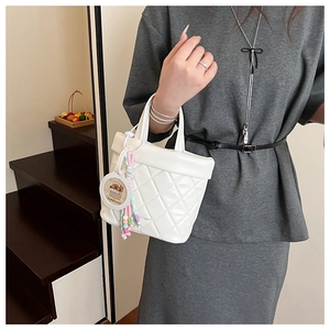 Detailed shot of white quilted tote bag with cute capybara pendant and beaded charms