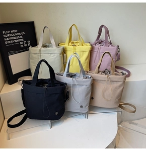Detail view of multi-color drawstring nylon tote bags in six different vibrant shades