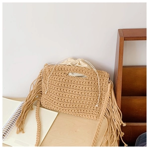 Detail of hand-woven cotton crochet bag showing fringe accents and drawstring liner
