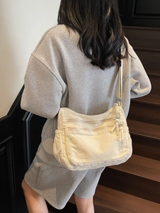 Cream canvas tote bag with multi-pocket design shown on model for daily commuting