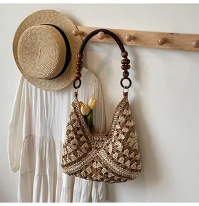 Detail of woven tote bag featuring wooden beads handle and hollow crochet pattern