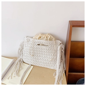 Detail of bohemian cotton crochet shoulder bag with intricate woven fringe and drawstring liner