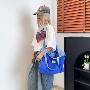 Gros plan d'un sac cabas bleu à texture gaufrée avec doublure intérieure à motif écrit