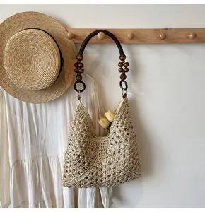 Detail of woven straw tote with wooden beads and round handle for beach resort style