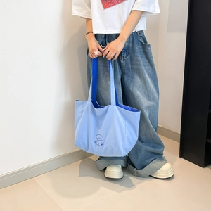 Gros plan du sac fourre-tout en toile bleu clair avec motif chien et doublure bleue