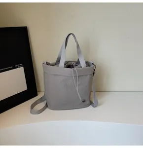 Detail of grey nylon bucket bag with adjustable strap and drawstring closure system