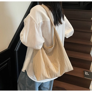 Detail of pleated beige tote bag featuring live laugh love & bread embroidery