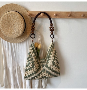 Detail of hand-woven shoulder bag with wooden beads strap and green geometric pattern
