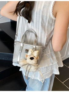 Sparkly silver sequin bucket bag for women with a cute white plush puppy charm decoration