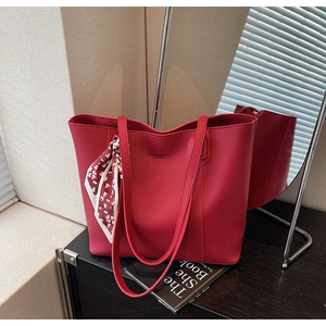 Detail of red faux leather tote bag with printed scarf and long shoulder strap
