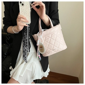 Pink quilted crossbody bag with cute capybara pendant and beaded handle detail