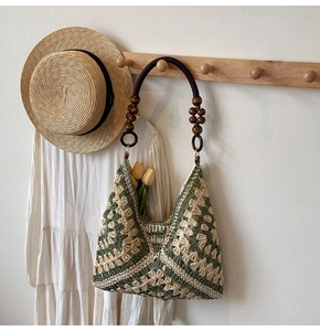Detail of hand-woven green geometric hobo bag with polished dark brown wooden bead handles
