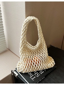 Minimalist beige hollow knit tote bag with citrus fruit inside showing a mesh texture