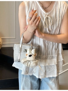 Silver glitter bucket bag with wavy texture and white plush bear charm accessory