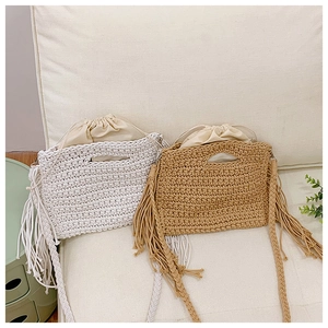 Detailed close-up of woven cotton tote bag with side tassels and drawstring inner pouch