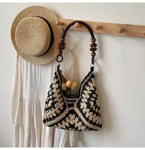 Detailed view of woven tote with geometric patterns and decorative wooden bead handles