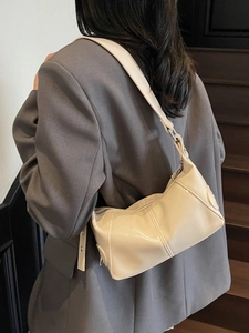 Borsa a spalla chic color crema da donna con cuciture verticali indossata da modella