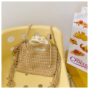 Detail of bohemian cotton crochet tote bag featuring side fringe and drawstring liner