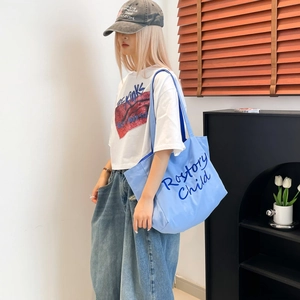 Détail du sac fourre-tout bleu clair en toile avec imprimé typographique Rostory Child