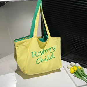 Détail de la broderie Rostory Child verte sur le sac fourre-tout en toile jaune à anses