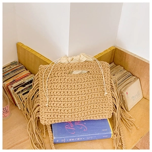 Close-up of bohemian woven cotton shoulder bag with fringe detail and drawstring liner