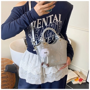 Vue détaillée du sac seau argenté à texture serpent avec poignées rondes et breloque