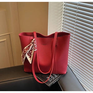 Close-up of red lychee pattern tote bag featuring a printed silk scarf on the handle