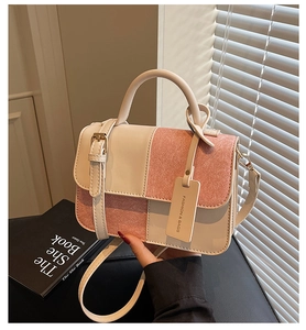 Detail of color-block handbag with pink sequins and fashion tag in natural light