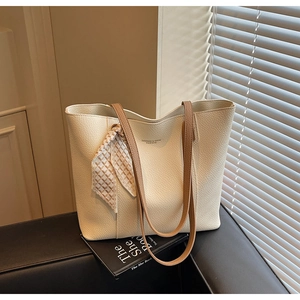 Detailed close-up of cream tote bag with litchi texture leather and silk scarf