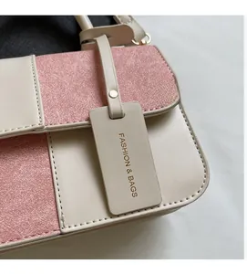 Detail of pink glitter and beige leather stitching with FASHION & BAGS charm