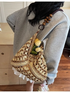 Handcrafted woven tote bag with floral patterns and wooden bead straps for summer beach use