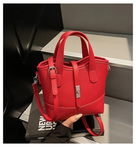 Dettaglio della borsa a secchiello in pelle rossa con chiusura a scatto argento