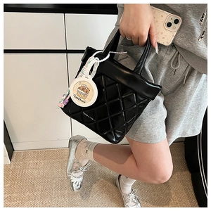 Detailed shot of black quilted handbag with premium stitching and a cute Capybara charm