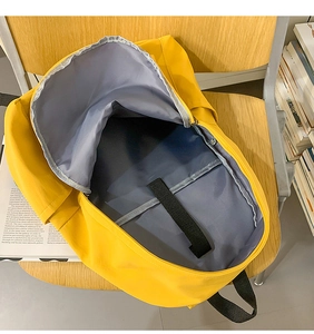 Top view of yellow backpack interior showing large capacity and grey lining with strap