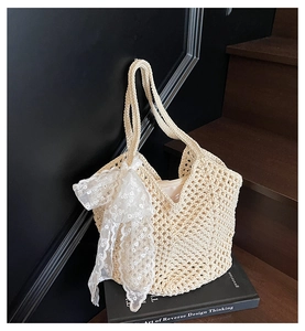 Détail du sac cabas tissé avec nœud en dentelle florale et doublure à fermeture éclair